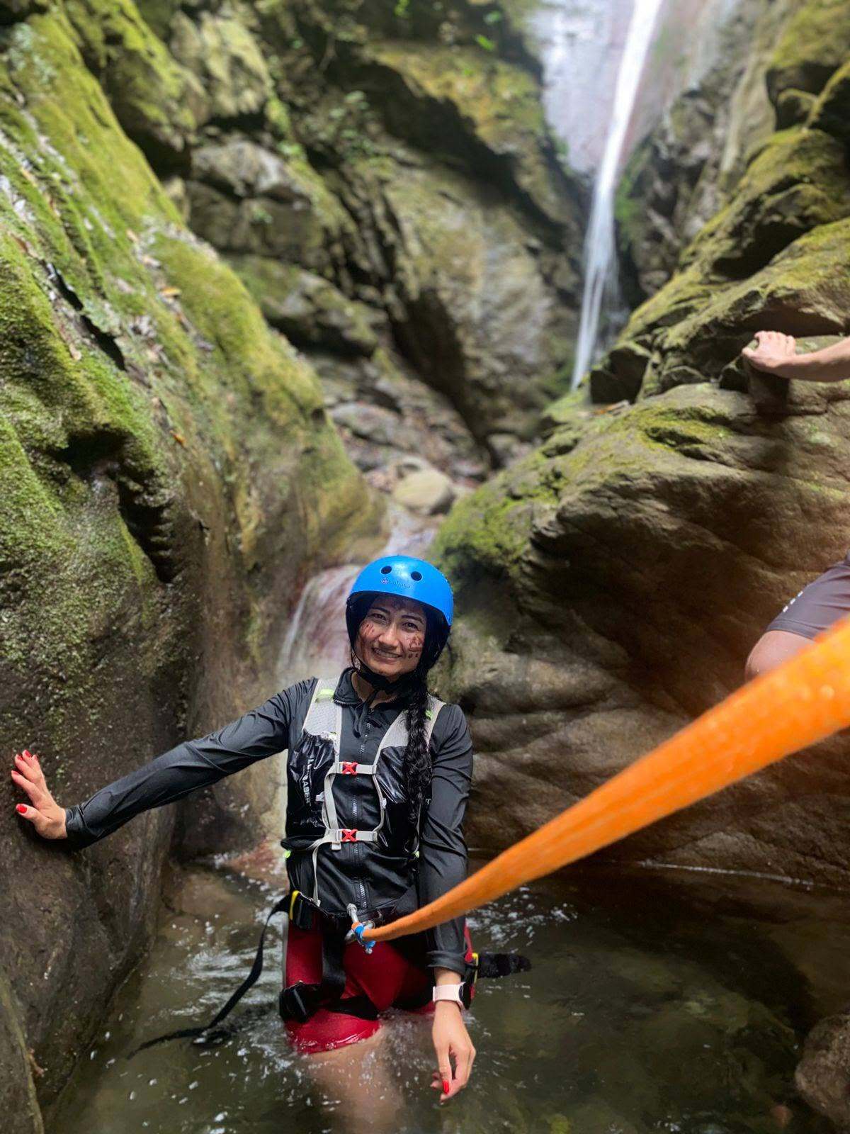 Visitante con casco y arnés avanzando por el cañón de la ruta Las Golondrinas