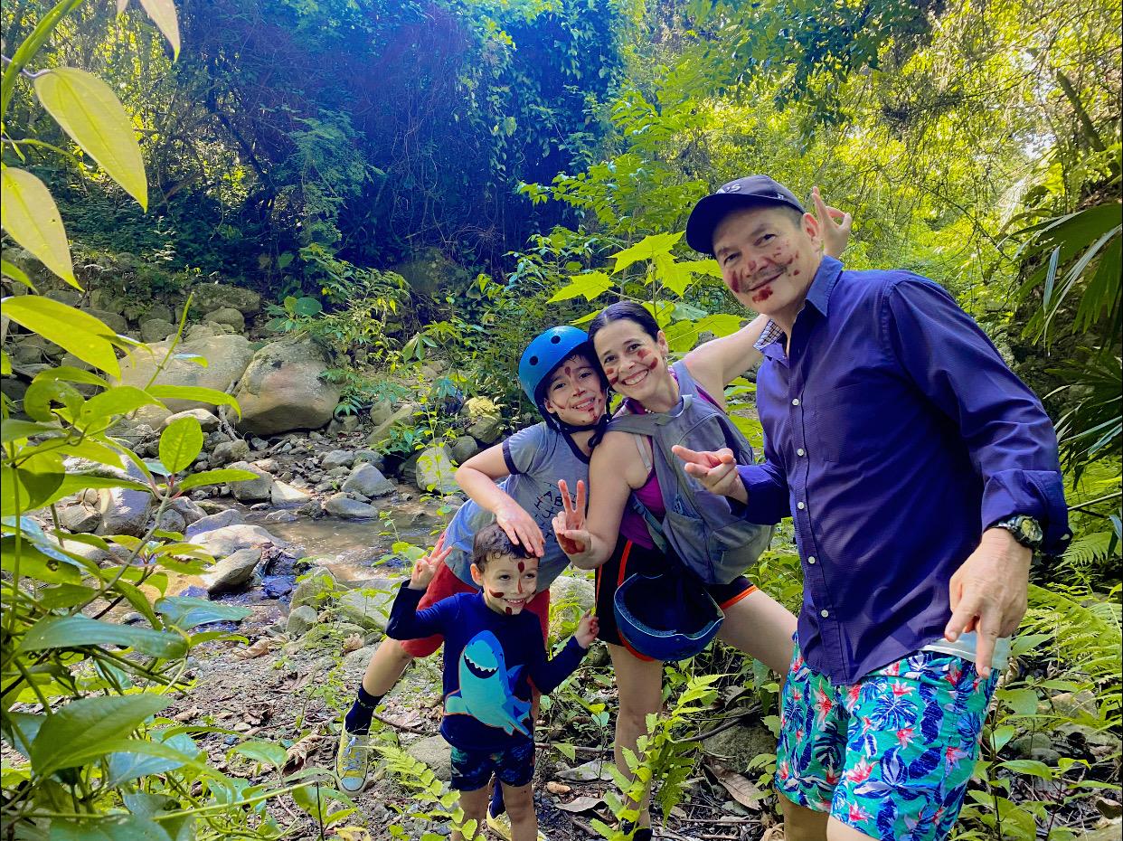 Familia sonriente durante una caminata por la quebrada en Caminos del César