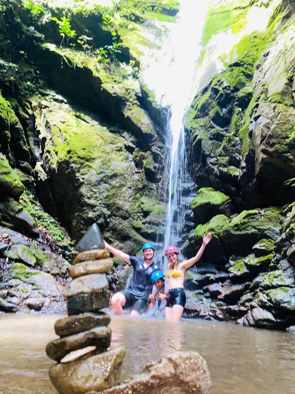 Grupo con cascos bajo la cascada de la ruta Las Golondrinas